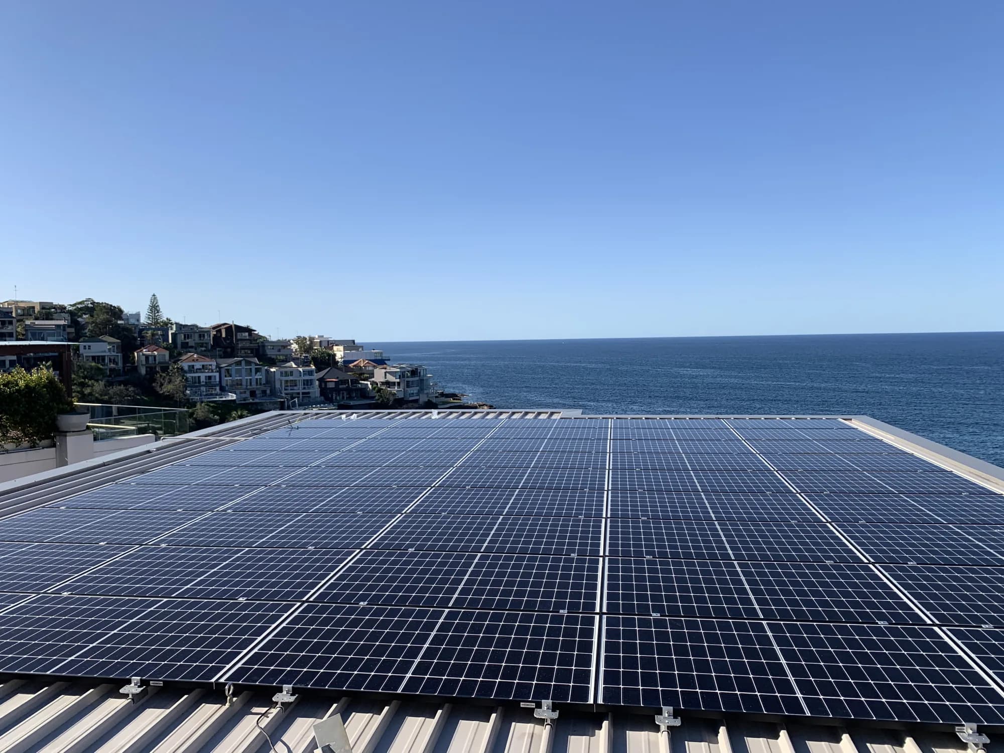 Black monocrystalline panels flush-mounted on a coastal Sydney rooftop